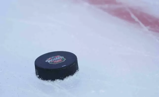 A puck rests on the ice during the Chicago Blackhawks practice on the day before the NHL Winter Classic outdoor hockey game featuring the Blackhawks and the St. Louis Blues at Wrigley Field, Monday, Dec. 30, 2024, in Chicago. (AP Photo/Erin Hooley)