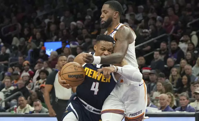 Denver Nuggets guard Russell Westbrook (4) drives on Phoenix Suns forward Royce O'Neale during the first half of an NBA basketball game, Wednesday, Dec. 25, 2024, in Phoenix. (AP Photo/Rick Scuteri)