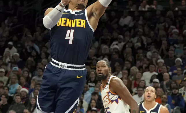 Denver Nuggets guard Russell Westbrook (4) drives past Phoenix Suns forward Kevin Durant during the first half of an NBA basketball game, Wednesday, Dec. 25, 2024, in Phoenix. (AP Photo/Rick Scuteri)