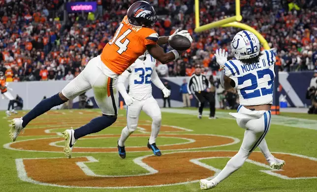 Denver Broncos' Courtland Sutton drops a pass in front of Indianapolis Colts' Kenny Moore II during the second half of an NFL football game Sunday, Dec. 15, 2024, in Denver. (AP Photo/Jack Dempsey)