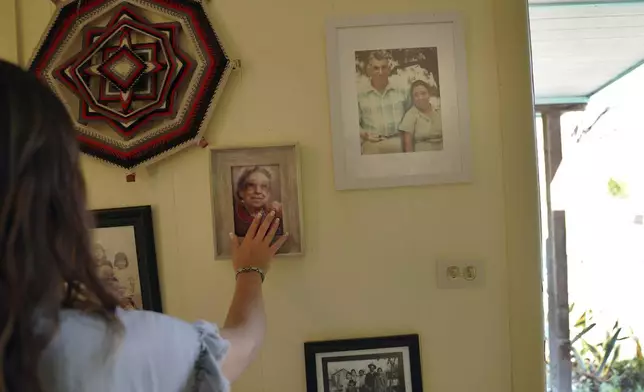 Photos of the late Amada Cardenas and her husband, who were the first federally licensed peyote dealers to harvest and sell the sacramental plant to followers of the Native American Church, hang in her home in Mirando City, Texas, Monday, March 25, 2024. (AP Photo/Jessie Wardarski)