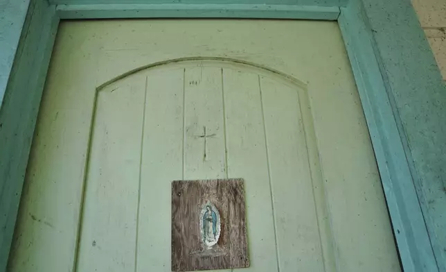 An image of Our Lady of Guadalupe hangs on the door of the late Amada Cardenas’ home, who was one of the first federally licensed peyote dealers, alongside her husband, to harvest and sell the sacramental plant to followers of the Native American Church, in Mirando City, Texas, Monday, March 25, 2024. (AP Photo/Jessie Wardarski)