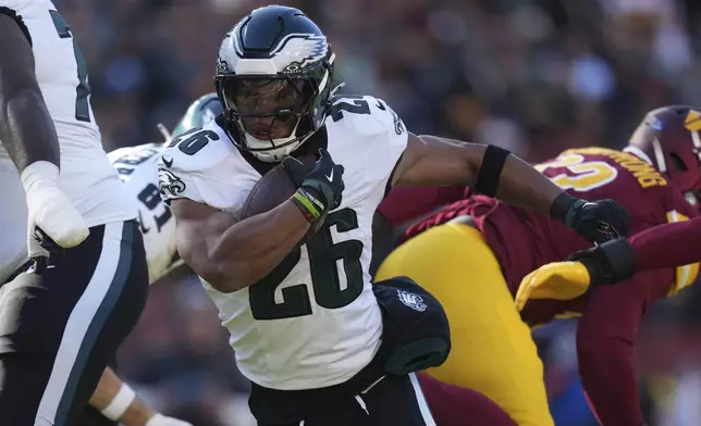 Philadelphia Eagles running back Saquon Barkley (26) running with the ball during the first half of an NFL football game against the Washington Commanders, Sunday, Dec. 22, 2024, in Landover, Md. (AP Photo/Stephanie Scarbrough)