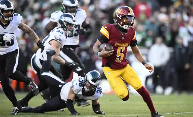 Washington Commanders quarterback Jayden Daniels (5) running with the ball during the second half of an NFL football game against the Philadelphia Eagles, Sunday, Dec. 22, 2024, in Landover, Md. (AP Photo/Nick Wass)