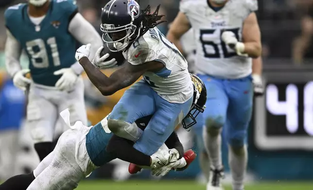 Tennessee Titans wide receiver Calvin Ridley (0) is tackled by Jacksonville Jaguars cornerback Montaric Brown after catch during the second half of an NFL football game, Sunday, Dec. 29, 2024, in Jacksonville, Fla. (AP Photo/Phelan M. Ebenhack)