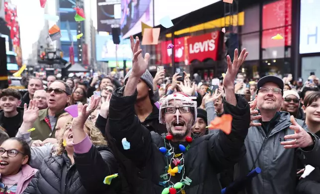 People in the crowd catch confetti ahead of New Year's Eve in Times Square, Sunday, Dec. 29, 2024, in New York. (AP Photo/Heather Khalifa)