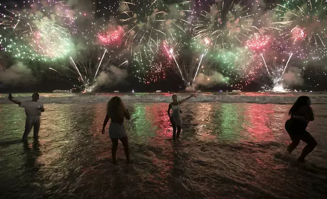 FILE - People celebrate the start of the New Year as fireworks illuminate Copacabana Beach in Rio de Janeiro, Brazil, early Monday, Jan. 1, 2024. (AP Photo/Bruna Prado, File)