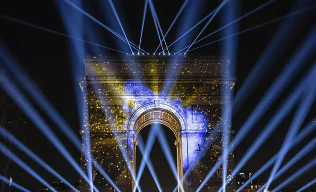 FILE - A light show is projected on the Arc de Triomphe during a New Year's celebration on the Champs Elysees in Paris, France, Sunday, Dec. 31, 2023. (AP Photo/Aurelien Morissard, File)