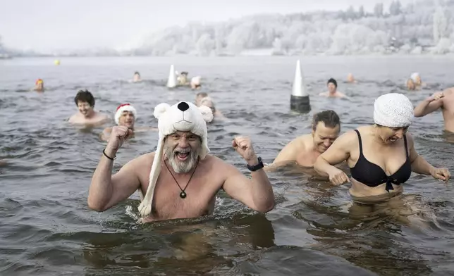 Swimmers attend the traditional New Year's Eve swimming at lake Moossee in Moosseedorf, Switzerland, Tuesday, December 31, 2024. (Anthony Anex/Keystone via AP)