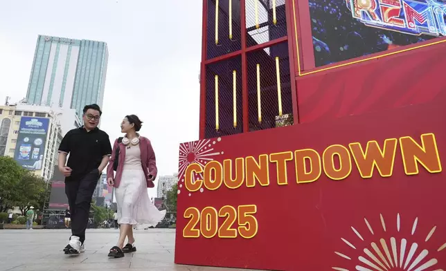 A young couple enter the venue for a New Year countdown concert in Ho Chi Minh city, Vietnam on Tuesday, Dec. 31, 2024. (AP Photo/Hau Dinh)