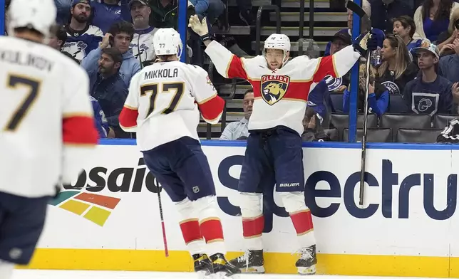 Florida Panthers left wing A.J. Greer (10) celebrates after his goal against the Tampa Bay Lightning with defenseman Niko Mikkola (77) during the second period of an NHL hockey game Sunday, Dec. 22, 2024, in Tampa, Fla. (AP Photo/Chris O'Meara)