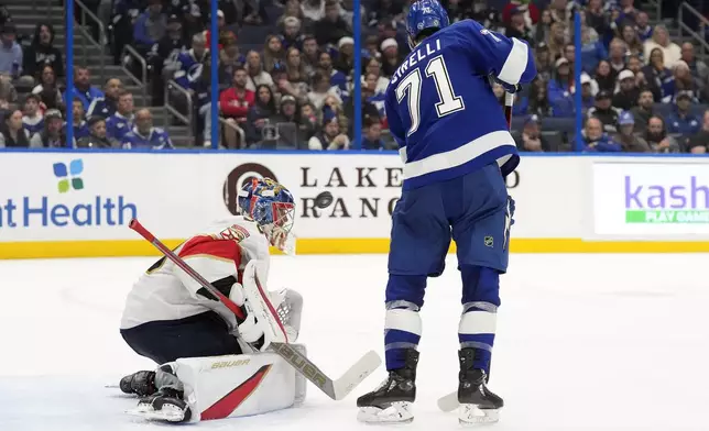 Florida Panthers goaltender Spencer Knight, left, makes a save on a deflection by Tampa Bay Lightning center Anthony Cirelli (71) during the second period of an NHL hockey game Sunday, Dec. 22, 2024, in Tampa, Fla. (AP Photo/Chris O'Meara)