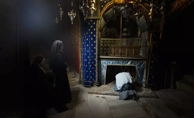 Worshippers pray at the Church of the Nativity, traditionally believed to be the birthplace of Jesus, on Christmas Eve, in the West Bank city of Bethlehem, Tuesday, Dec. 24, 2024. (AP Photo/Matias Delacroix)