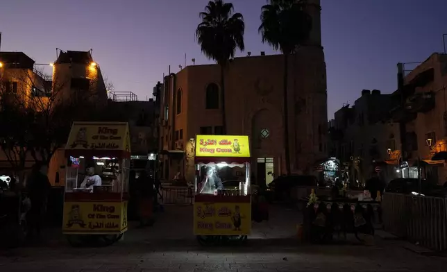 A street vendor cooks corn ahead of Christmas in the West Bank city of Bethlehem, Monday, Dec. 23, 2024. (AP Photo/Matias Delacroix)