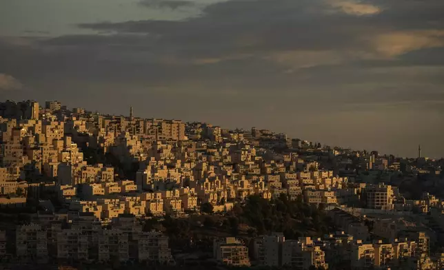 The sun rises over homes covering a hill of the West Bank city of Bethlehem, on Christmas Eve, Tuesday, Dec. 24, 2024. (AP Photo/Matias Delacroix)