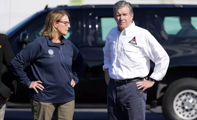 FILE- North Carolina Gov. Roy Cooper, right, and Deanne Criswell, Administrator of the U.S. Federal Emergency Management Agency, await the arrival of Democratic presidential nominee Vice President Kamala Harris for a briefing on the damage from Hurricane Helene, at Charlotte Douglas International Airport, in Charlotte, N.C., Oct. 5, 2024. (AP Photo/Chris Carlson, File)