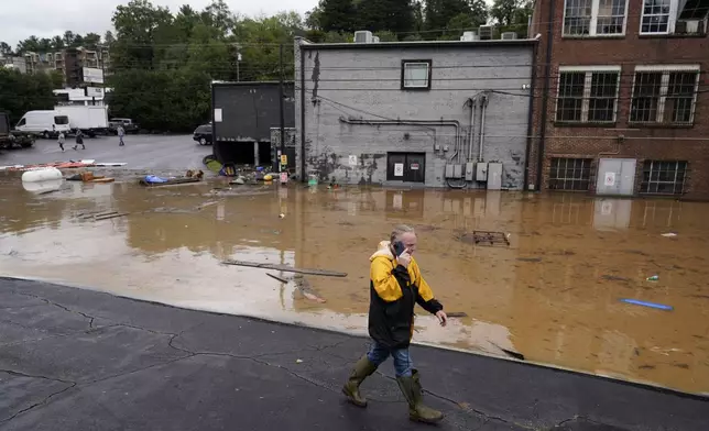 FILE - A man walks near a flooded area near the Swannanoa river, effects from Hurricane Helene , Friday, Sept. 27, 2024, in Asheville, N.C. (AP Photo/Erik Verduzco, File)