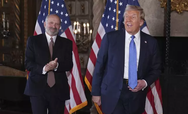 President-elect Donald Trump departs a news conference at Mar-a-Lago, Monday, Dec. 16, 2024, in Palm Beach, Fla., followed by Commerce Secretary nominee Howard Lutnick. (AP Photo/Evan Vucci)