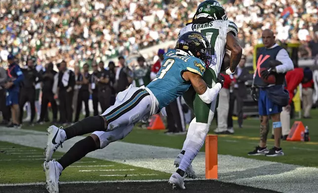 New York Jets wide receiver Davante Adams (17) is hit by Jacksonville Jaguars cornerback Tyson Campbell (3) after a sucessful two-point conversion during the second half of an NFL football game Sunday, Dec. 15, 2024, in Jacksonville, Fla. (AP Photo/Phelan M. Ebenhack)