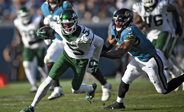 New York Jets wide receiver Garrett Wilson, left, gets away from Jacksonville Jaguars safety Andre Cisco after a catch during the second half of an NFL football game Sunday, Dec. 15, 2024, in Jacksonville, Fla. (AP Photo/Phelan M. Ebenhack)