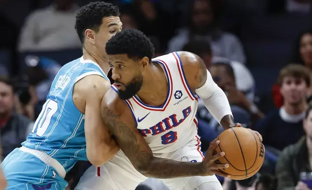 Philadelphia 76ers forward Paul George (8) looks to drive against Charlotte Hornets guard Josh Green, left, during the first half of an NBA basketball game in Charlotte, N.C., Monday, Dec. 16, 2024. (AP Photo/Nell Redmond)