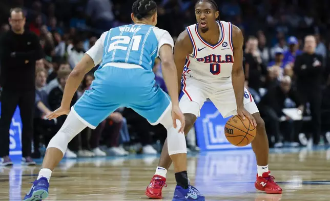 Philadelphia 76ers guard Tyrese Maxey (0) goes up against Charlotte Hornets guard Isaiah Wong (21) during the second half of an NBA basketball game in Charlotte, N.C., Monday, Dec. 16, 2024. (AP Photo/Nell Redmond)