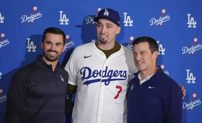 Los Angeles Dodgers pitcher Blake Snell, center, poses for photos with president of baseball operations Andrew Friedman, right, and general manager Brandon Gomes during a news conference Tuesday, Dec. 3, 2024, in Los Angeles. (AP Photo/Jae C. Hong)