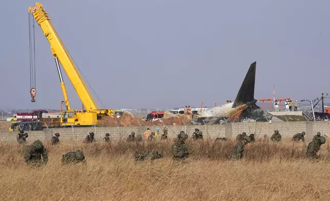 South Korean army soldiers work outside of Muan International Airport in Muan, South Korea, Sunday, Dec. 29, 2024. (AP Photo/Ahn Young-joon)