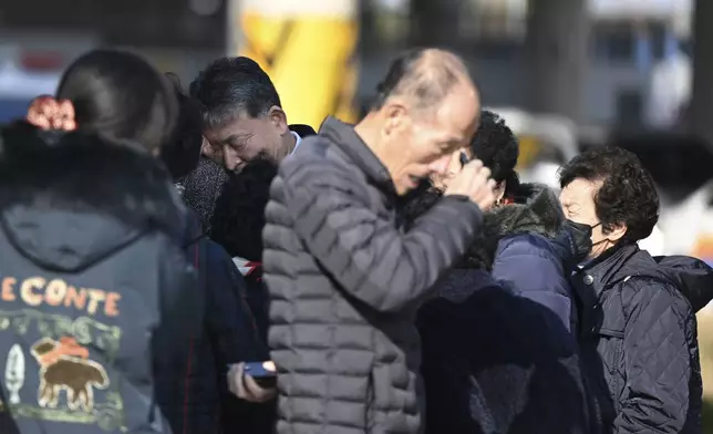 Family members of the passengers on a plane which burst into flames, weep at the Muan International Airport in Muan, South Korea, Sunday, Dec. 29, 2024. (Park Ki-woong/Newsis via AP)