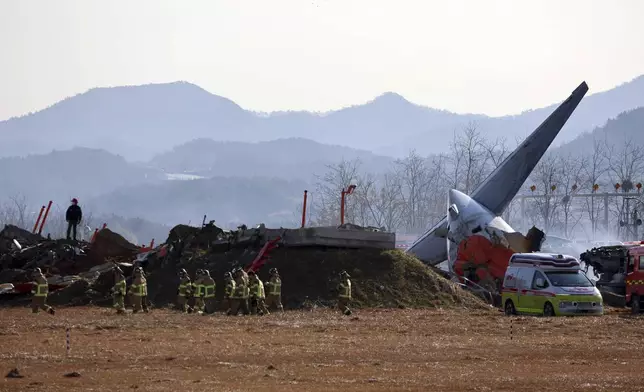 Firefighters and rescue team members work at Muan International Airport in Muan, South Korea, Sunday, Dec. 29, 2024. (Cho Nam-soo/Yonhap via AP)