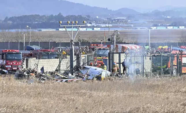 Firefighters and rescue team members work at Muan International Airport in Muan, South Korea, Sunday, Dec. 29, 2024. (Lee Young-ju/Newsis via AP)