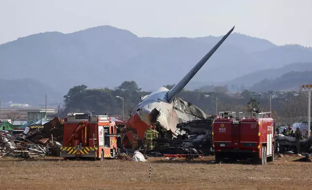 Firefighters and rescue team members work at Muan International Airport in Muan, South Korea, Sunday, Dec. 29, 2024. (Cho Nam-soo/Yonhap via AP)