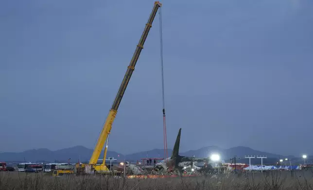 Rescue team members work at the site of a plane fire at Muan International Airport in Muan, South Korea, Sunday, Dec. 29, 2024. (AP Photo/Ahn Young-joon)