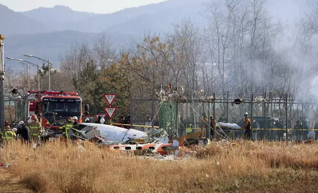 Firefighters and rescue team members work at Muan International Airport in Muan, South Korea, Sunday, Dec. 29, 2024. (Cho Nam-soo/Yonhap via AP)