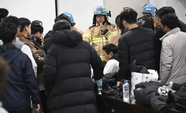 An official from fire station briefs to the family members of the passengers on a plane which burst into flames, at the Muan International Airport in Muan, South Korea, Sunday, Dec. 29, 2024. (Park Ki-woong/Newsis via AP)