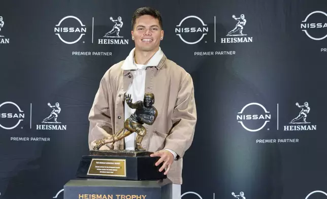 Heisman Trophy finalist Dillon Gabriel poses with the trophy during a college football media availability, Friday, Dec. 13, 2024, in New York. (AP Photo/Corey Sipkin)