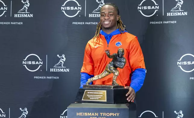 Heisman Trophy finalist Ashton Jeanty, of Boise State, poses with the trophy during a college football media availability, Friday, Dec. 13, 2024, in New York. (AP Photo/Corey Sipkin)