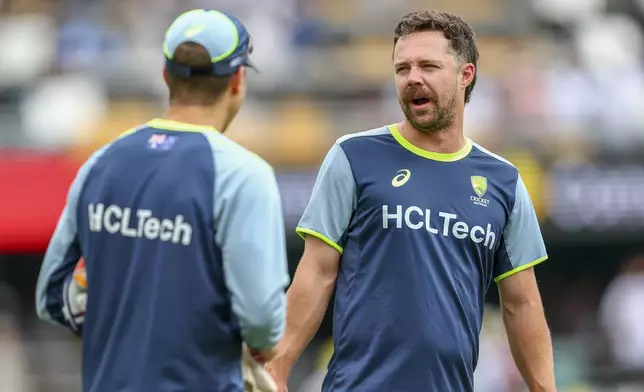 Australia's Travis Head, right, chats with teammate Alex Carey ahead of day one of the third cricket test between India and Australia at the Gabba in Brisbane, Australia, Saturday, Dec. 14, 2024. (AP Photo/Pat Hoelscher)