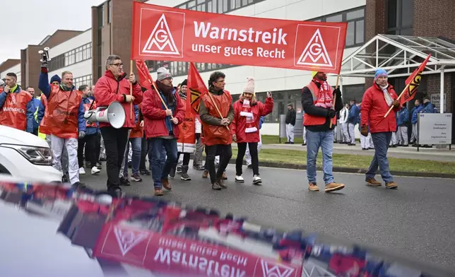 Volkswagen workers march holding a sign with writing reading in German "Warning strike is our right" on the first day of a nationwide warning Volkswagen workers' strike, in Zwickau, Germany, Monday, Dec. 2, 2024. (Hendrik Schmidt/dpa via AP)