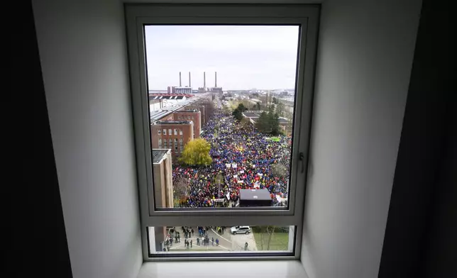 Volkswagen workers are seen through a window as they attend at a rally during at nationwide warning Volkswagen workers' strike, on the grounds of the main Volkswagen plant in Wolfsburg, Germany, Monday, Dec. 2, 2024. (Julian Stratenschulte/Pool Photo via AP)