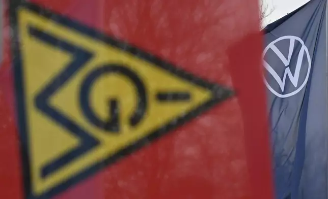 An IG Metall trade union flag flies at the gate of a Volkswagen plant on the first day of a nationwide Volkswagen workers' strike, in Zwickau, Germany, Monday, Dec. 2, 2024. (Hendrik Schmidt/dpa via AP)