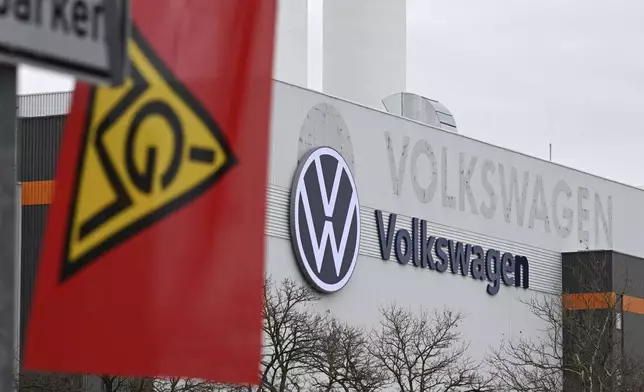 An IG Metall trade union flag flies at the gate of a Volkswagen plant on the first day of a nationwide Volkswagen workers' strike, in Zwickau, Germany, Monday, Dec. 2, 2024. (Hendrik Schmidt/dpa via AP)