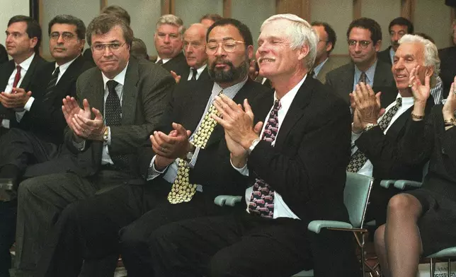 FILE - Turner Broadcasting Systems Chairman &amp; CEO Ted Turner, right foreground, and Richard Parsons, Time Warner president, to Turner's right, applaud the outcome of the Time Warner shareholders' vote, in New York, Thursday, Oct. 10, 1996. (AP Photo/Marty Lederhandler, File)