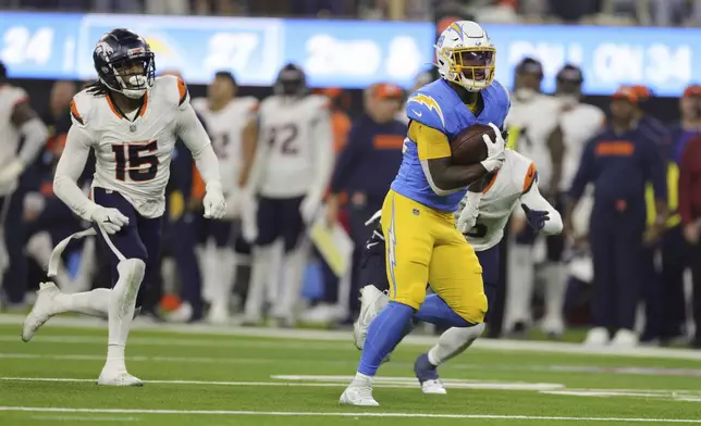 Los Angeles Chargers running back Hassan Haskins (28) scores a touchdown during the second half of an NFL football game against the Denver Broncos, Thursday, Dec. 19, 2024, in Inglewood, Calif. (AP Photo/Ryan Sun)