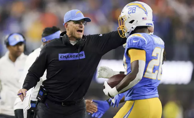 Los Angeles Chargers running back Hassan Haskins, left, celebrates his touchdown with head coach Jim Harbaugh during the second half of an NFL football game against the Denver Broncos, Thursday, Dec. 19, 2024, in Inglewood, Calif. (AP Photo/Ryan Sun)