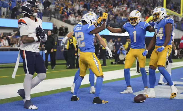 Los Angeles Chargers wide receiver Derius Davis (12) celebrates with teammates after a touchdown reception during the second half an NFL football game against the Denver Broncos, Thursday, Dec. 19, 2024, in Inglewood, Calif. (AP Photo/Eric Thayer)