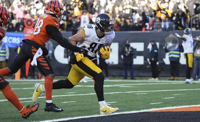 Pittsburgh Steelers tight end Pat Freiermuth, right, scores a touchdown ahead of Cincinnati Bengals cornerback Josh Newton (28) during the second half of an NFL football game Sunday, Dec. 1, 2024, in Cincinnati. (AP Photo/Joshua A. Bickel)