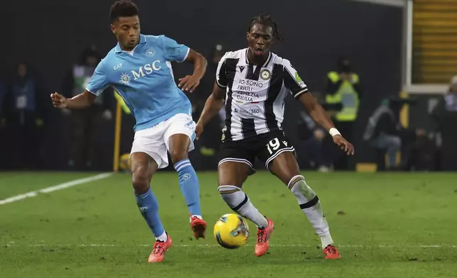 Napoli's David Neres fights for the ball with Udinese's Kingsley Ehizibue during the Serie A soccer match between Udinese and Napoli at the Bluenergy Stadium in Udine, Italy, Saturday, Dec. 14, 2024. (Andrea Bressanutti/LaPresse via AP)