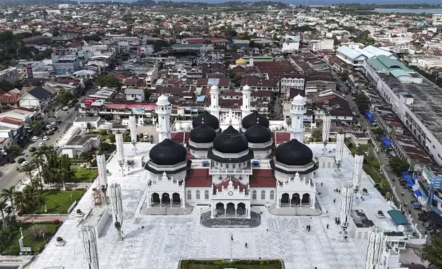 This aerial shot taken using a drone shows buildings at the business district surrounding Baiturrahman Grand Mosque which were badly ravaged by the Indian Ocean tsunami in 2004, in Banda Aceh , Indonesia, Thursday, Dec. 12, 2024. (AP Photo/Achmad Ibrahim)