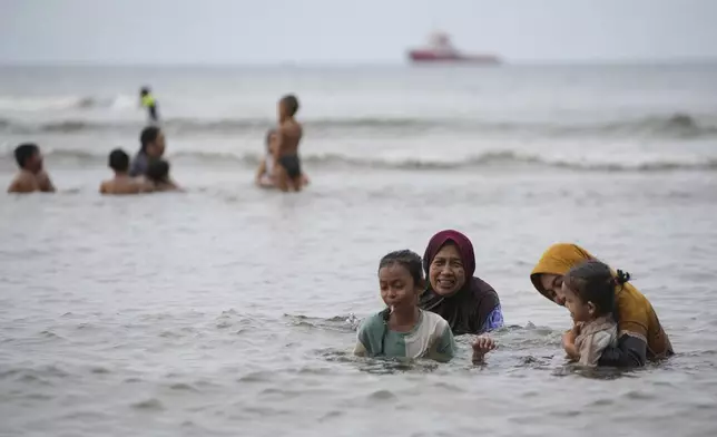 People play in the water at Ulee Lheue beach which was one of the areas hardest hit by Indian Ocean tsunami in 2004, in Banda Aceh, Aceh Province, Indonesia, Friday, Dec. 13, 2024. (AP Photo/Achmad Ibrahim)